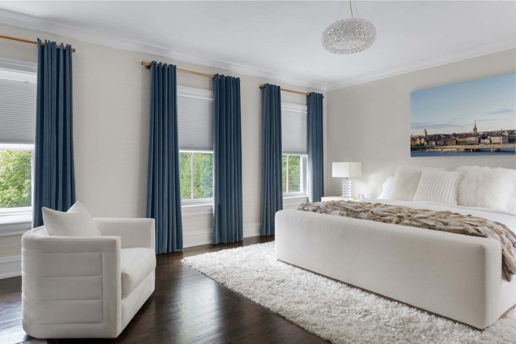 Elegant bedroom featuring luxury window treatments, showcasing a sophisticated design with stylish curtains and blinds.